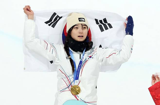 12일(현지시간) 이탈리아 리비뇨 스노파크에서 열린 2026 밀라노·코르티나담페초 동계올림픽 스노보드 여자 하프파이프 결선에서 90.25점을 받아 금메달을 획득한 스노보드 최가온이 태극기를 들고 기뻐하고 있다. 뉴스1