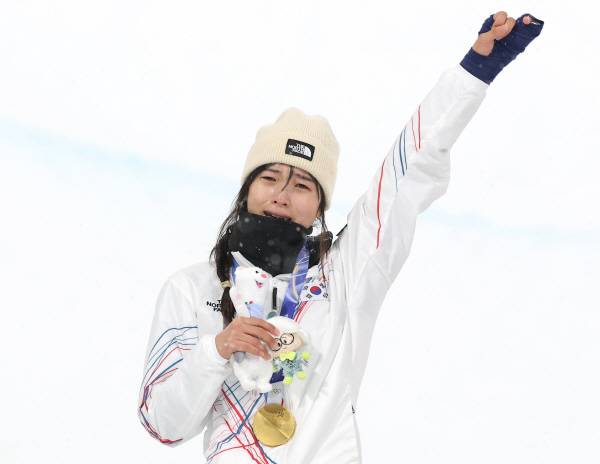 13일(한국시간) 이탈리아 리비뇨 스노파크에서 열린 2026 밀라노·코르티나담페초 동계올림픽 스키 스노보드 여자 하프파이프 결선에서 90.25점을 획득해 금메달을 획득한 한국 최가온이 시상대에 올라 눈물을 흘리며 팔을 들어보이고 있다. 연합뉴스