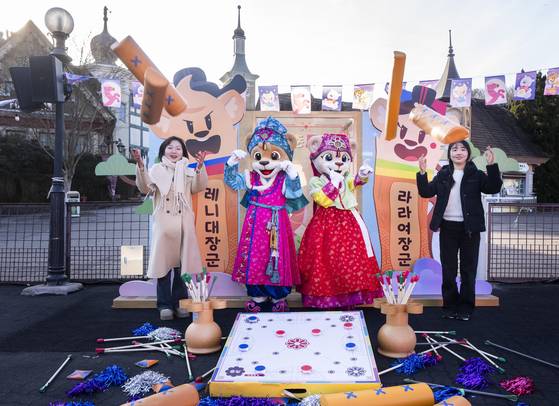 Visitors and employees to Everland, in Yonggin, Gyeonggi, pose for photos with Seollal-themed items. [EVERLAND]