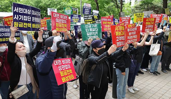 Members of a victims’ group related to the Hang Seng Index-linked equity-linked securities (ELS) fallout chant slogans at a news conference in front of the Financial Supervisory Service in Yeouido, western Seoul, on April 24, 2024, calling for the prosecution of financial institutions, executives and a former financial regulator chief, and demanding full compensation. [YONHAP]