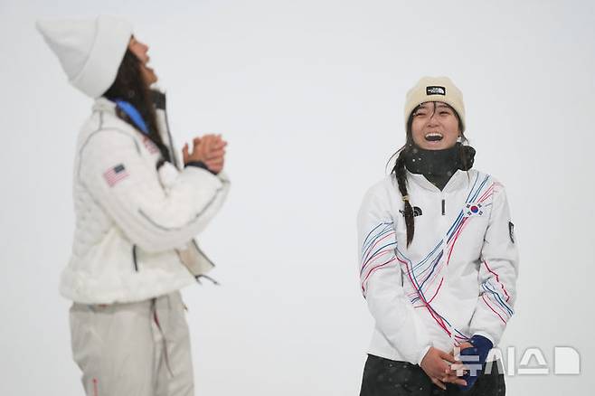 [리비뇨=AP/뉴시스] 13일(한국 시간) 이탈리아 리비뇨 스노파크에서 열린 2026 밀라노·코르티나담페초 동계올림픽 스노보드 여자 하프파이프 경기 후 은메달리스트 클로이 김(미국·왼쪽)이 금메달리스트 최가온이 소개되자 박수를 치고 있다. 2026.02.13.