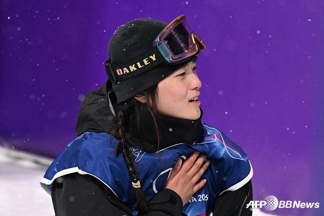스노보드 최가온이 13일 이탈리아 리비뇨 스노파크에서 열린 2026 밀라노·코르티나담페초 동계올림픽 스노보드 여자 하프파이프 결선에서 90.25점으로 레이스를 마치고 기뻐하고 있다. /AFPBBNews=뉴스1