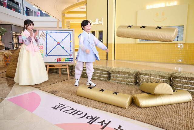 스타필드 하남에서 진행 중인 ‘짚(ZIP)에서 놀자’ 팝업 전시(2/12~2/18)에서 어린이 모델들이 윷놀이를 하고 있다.(스타필드 제공)