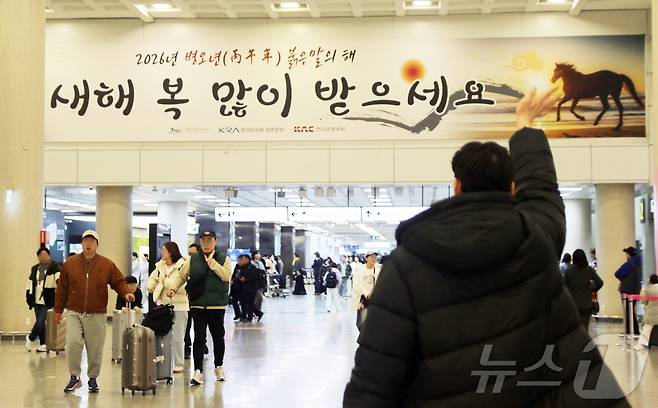 설 연휴가 시작된 14일 오전 제주국제공항 1층에서 시민이 손을 흔들며 인사하고 있다. 제주도관광협회에 따르면 이번 연휴 동안 제주도에는 입도객 24만5000여 명이 올 것으로 예상된다.2026.2.14 ⓒ 뉴스1 홍수영 기자