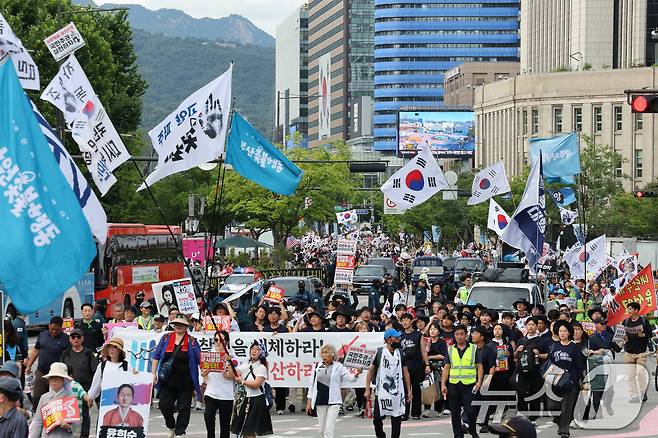 광복절 연휴 둘째 날인 지난해 8월 16일 진보와 보수 단체들이 각각 도심 한복판에서 태극기를 앞세워 광복 80주년을 기념하는 대규모 집회를 벌였다. 진보 성향 단체 촛불행동 참가자들(사진 앞쪽)이 153차 전국집중 촛불대행진을 열고 내란세력 청산을 촉구하며 서울광장 앞을 지나는 순간, 행진 대열 뒷편에 보수성향 단체 대한민국바로세우기국민운동본부가 주최한 '광복 80주년 8.15 국가정상화를 위한 광화문 국민대회' 참가자들의 모습이 보인다. ⓒ 뉴스1 오대일 기자