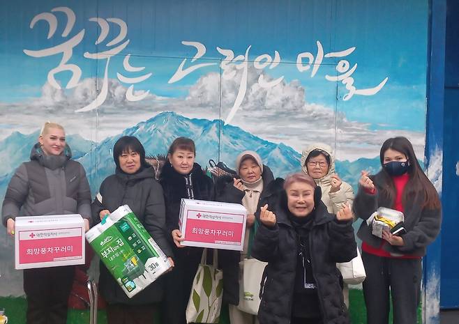 자원 봉사자들과 포즈 취한 신조야 대표 (광주=연합뉴스) 박현수 기자 = 11일 광주 고려인마을에서 신조야(오른쪽서 3번째) 대표가 고려인들에게 전달할 기부받은 생필품을 들고 자원봉사자들과 함께 기념촬영을 하고 있다. 2026. 2. 11. phyeonsoo@yna.co.kr