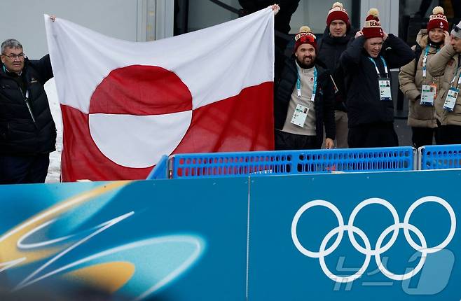 11일(현지시간) 테르셀바 바이애슬론 아레나에서 열린 2026 밀라노·코르티나담페초 동계올림픽 여자 바이애슬론 개인전에서 덴마크 대표단이 그린란드 국기를 들고 있는 모습. (사진은 기사 내용과 무관함) / 뉴스1 ⓒ News1 ⓒ AFP=뉴스1