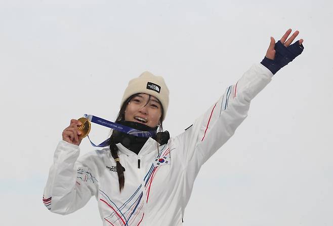 최가온이 13일(한국시간) 이탈리아 리비뇨 스노파크에서 열린 2026 밀라노-코르티나 동계올림픽 스노보드 여자 하프파이프 결승에서 우승한 후 금메달을 손에 들고 미소를 짓고 있다. 사진 | 연합뉴스
