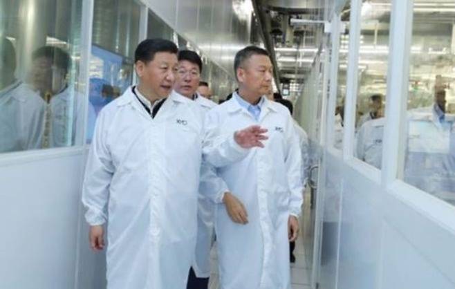 시진핑(왼쪽) 중국 국가주석이 2018년 중국 후베이성 우한에 있는 창장춘추(YMTC) 공장에서 자오웨이궈(가운데) 당시 쯔광그룹 회장, 양스닝(오른쪽) 창장춘추 당시 최고경영자와 함께 반도체 생산 라인을 둘러보고 있다. ⓒ 쯔광그룹 홈페이지 캡처