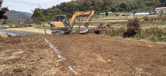 굴착기를 불러서 비닐하우스 들어설 자리를 정리하고 있다. 바닥이 평평해야 비닐하우스도 반듯하게 지어진다.