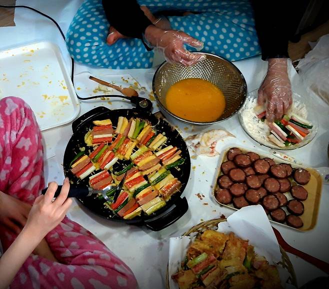 ‘거실에서 전기 프라이팬 놓고 양반다리로 앉아 전을 부치는 모습’은 설날이 되면 흔히 보는 장면이다. 하지만 앉아서 전을 부치면 허리와 관절 등에 큰 무리가 된다. 올해 설 음식 준비부터는 식탁 의자에 앉아서 전을 구워보자. 훨씬 편해진 몸 상태를 경험할 수 있을 것이다. 게티이미지뱅크