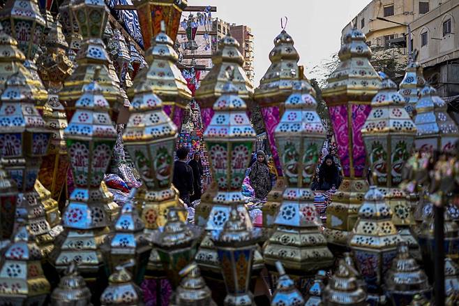 12일(현지시간) 이집트 카이로 중심가에서 시민들이 라마단을 앞두고 전통 등불을 고르고 있다. 사진=AFP·연합뉴스