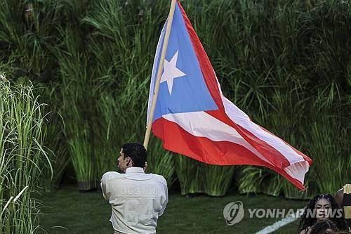 독립 상징하는 푸에르토 깃발 들고 있는 배드 버니 [EPA 연합뉴스 자료사진. 재판매 및 DB 금지]
