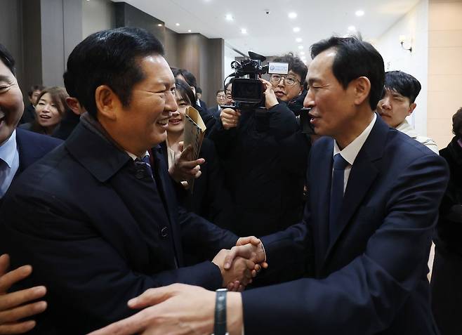 정청래 더불어민주당 대표가 지난 4일 당원 대상 특별 강연을 위해 강원 춘천시 스카이 컨벤션에 도착하며 우상호 전 청와대 정무수석과 악수하고 있다.   연합뉴스