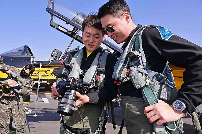 공군 제53특수비행전대 위인태 원사(진, 왼쪽)가 함께 항공촬영을 마친 블랙이글스 조종사와 촬영 결과물을 공유하고 있다. 사진 공군