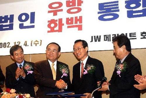 2002년 12월 4일 법무법인 우방과 법무법인 화백이 통합을 결정하며 다음해 '법무법인 화우'가 출범했다. 노경래 화백 대표변호사(왼쪽에서 두번째), 윤호일 우방 대표변호사(세번째)가 손을 맞잡고 있다. 화우 제공