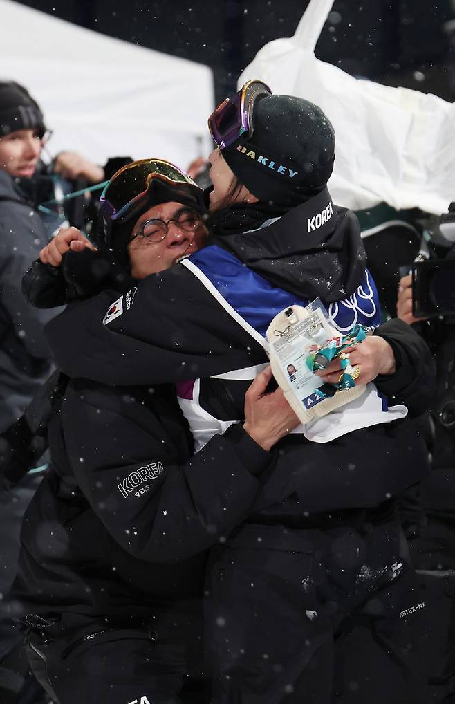 김수철 스노보드 프리스타일 대표팀 감독(왼쪽)이 지난 13일(한국시간) 이탈리아 리비뇨 스노파크에서 열린 밀라노·코르티나담페초 동계올림픽 스노보드 여자 하프파이프 결승에서 최가온과 안으며 기뻐하고 있다. 연합뉴스