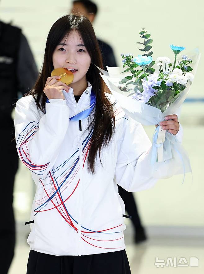 [인천공항=뉴시스] 최진석 기자 = 2026 밀라노·코르티나담페초 동계 올림픽 스노보드 여자 하프파이프 금메달을 획득한 최가온이 16일 인천국제공항 제2여객터미널을 통해 귀국해 금메달을 깨물고 있다. 최가온은 한국 설상 종목 1호 금메달리스트가 됐다. 이는 이번 대회에서 수확한 한국 선수단의 첫 금메달이다. 2026.02.16. myjs@newsis.com