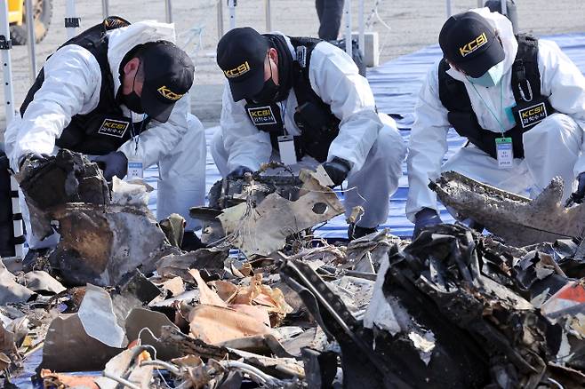 지난 12일 무안국제공항에서 국립과학수사연구원 관계자들이 12·29 제주항공 여객기 참사 사고기 잔해를 꺼내 다시 조사하고 있다. 연합뉴스