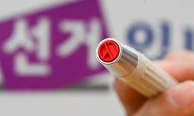 투표소에서 관계자가 기표 도장을 들어 보이고 있다. 연합뉴스