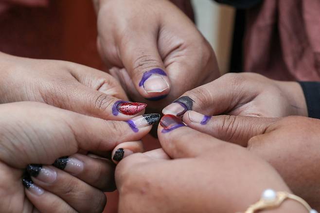 방글라데시 총선이 진행된 12일(현지시간) 수도 다카에서 투표를 마친 시민들이 잉크가 묻은 엄지를 보여주고 있다. 다카=EPA연합뉴스