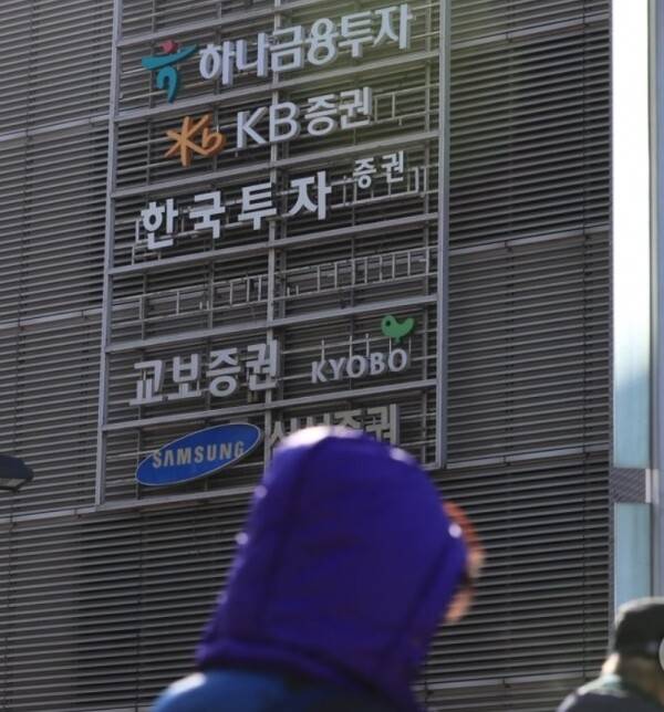 증권사별 간판이 걸린 서울 여의도 소재 건물 앞을 시민들이 지나가고 있다. / 사진=연합뉴스