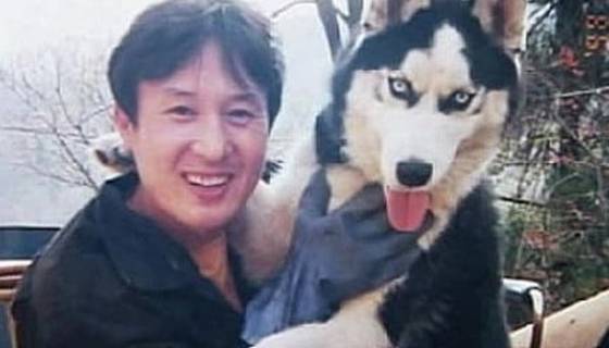 Kang Ho-sun, left, poses for a photo with a Siberian Husky in an undated file photo. It was alleged that he killed the dog after taking the photo. [YONHAP]