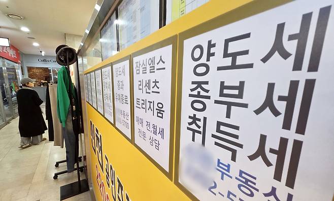 ‘다주택자 양도소득세 중과’ 조치가 오는 5월 9일부터 재시행된다. 다주택자가 보유한 조정대상지역 주택 양도차익에는 최고 75%(지방세 포함 82.5%)의 세율이 적용된다. 지난 12일 서울 시내 한 공인중개사 사무실 외벽에 부동산 관련 세금과 아파트 매매 물건 등의 안내문이 게시되어 있다. [연합]