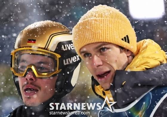 필립 라이문트(왼쪽)가 2026 밀라노·코르티나담페초 동계올림픽 스키점프 남자 슈퍼팀 결선 중 경기장을 바라보고 있다. /로이터=뉴스1