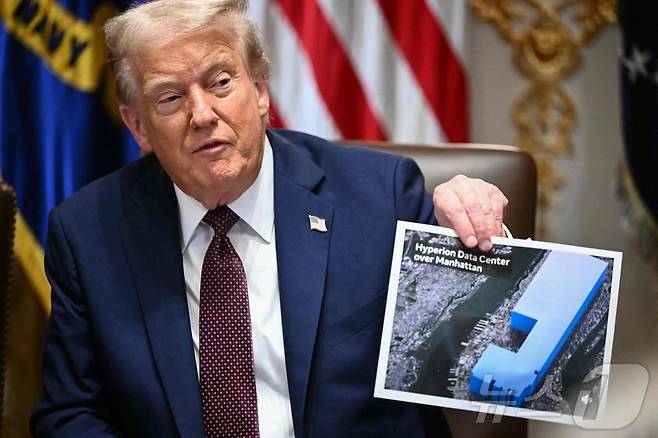 도널드 트럼프 미국 대통령이 26일(현지시간) 워싱턴DC 백악관 내각 회의에서 루이지애나에 건립을 추진하는 메타의 새 데이터 센터를 뉴욕 맨해튼에 겹치게 한 이미지를 들고 규모를 설명하고 있다. 2025.08.26. ⓒ AFP=뉴스1