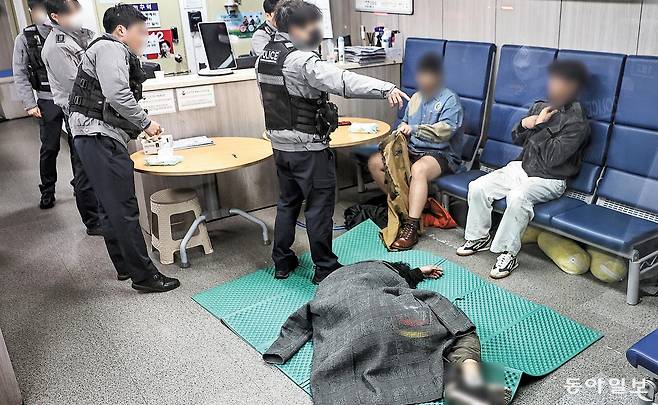 설 연휴의 시작인 14일 0시 무렵 서울 용산구 이태원파출소의 모습. 몸을 가누지 못할 정도로 취한 남성은 파출소 바닥에 누워 있었고, 술에 취해 바지를 벗은 한 남성과 만취해 소변을 본 취객을 상대하느라 경찰관들은 애를 먹었다. 이처럼 매일 약 2500건의 주취 신고 대응에 공권력이 동원되는 사이 강력 사건 등 긴급 출동의 ‘골든타임’에 대응할 여력은 줄어들 수밖에 없었다. 양회성 기자 yohan@donga.com