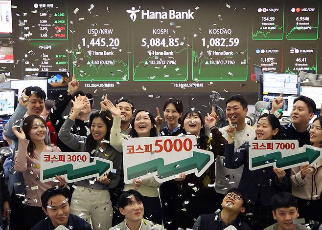 Hana Bank staff celebrate as the Kospi surpasses the 5,000 mark for the first time on Jan. 27. [NEWS1]