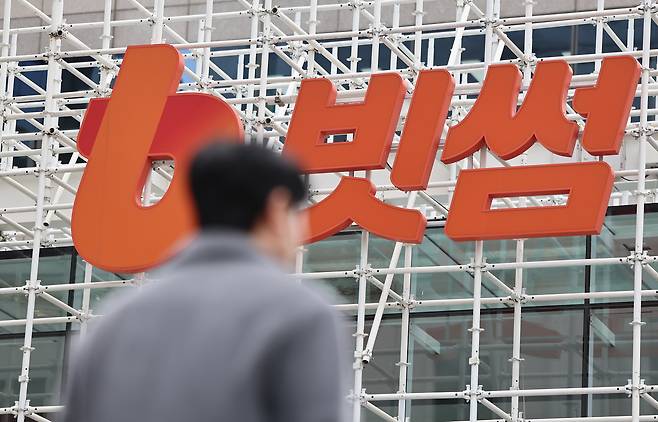 The Bithumb company logo is seen as a pedestrian walks by the Bithumb Lounge in Gangnam District, southern Seoul, on Feb. 12. [NEWS1]
