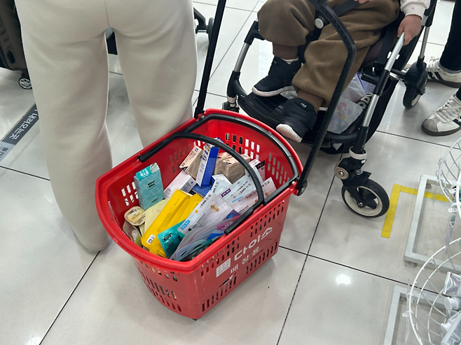 19일 방문한 다이소 명동점. 한 외국인 관광객이 뷰티 제품을 바구니에 담았다. [변덕호 기자]