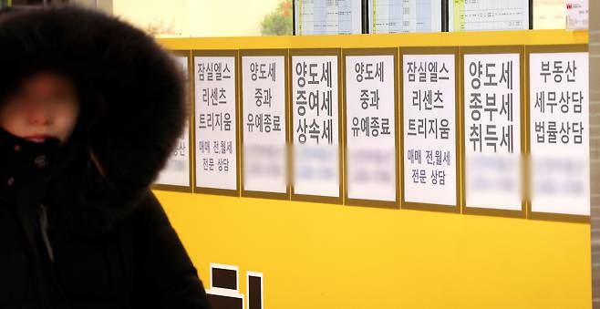 서울 잠실에 위치한 공인중개사 사무실 유리 벽에 부동산 관련 세금과 아파트 매매 물건 등의 안내문이 게시돼 있다. [연합]