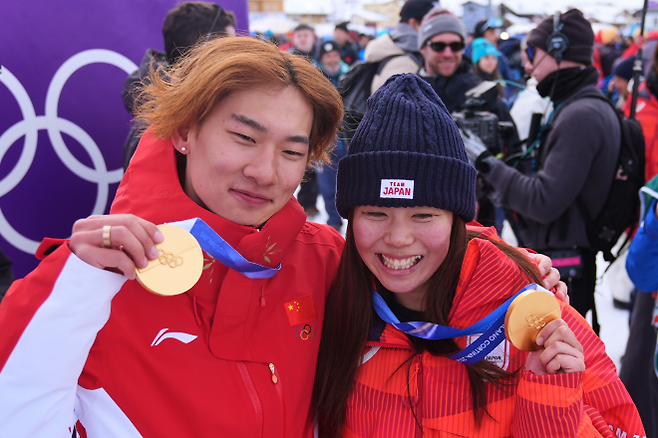 18일(현지시간) 2026 동계올림픽에서 스노보드 슬로프스타일에 출전해 중국에 첫 금메달을 안긴 쑤이밍(왼쪽)이 여자 스노보드 슬로프스타일 결승전 후 일본의 금메달리스트 후카다 마리와 함께 기뻐하고 있다. 리비뇨 AP 연합뉴스