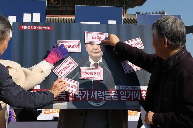 전국민중행동을 비롯한 시민단체 회원들이 내란 우두머리 혐의로 기소된 윤석열 전 대통령의 1심 선고가 진행되는 19일 서울 광화문 앞에서 기자회견을 열고 법정 최고형 선고를 촉구하는 퍼포먼스를 하고 있다. ⓒ연합뉴스