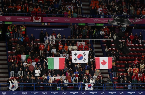 18일(현지시간) 이탈리아 밀라노 아이스스케이팅 아레나에서 열린 2026 밀라노-코르티나담페초 동계올림픽 쇼트트랙 여자 3000m 계주에서 대표팀이 금메달을 따낸 가운데 시상식에서 태극기가 올라가 있다. [밀라노=연합뉴스]