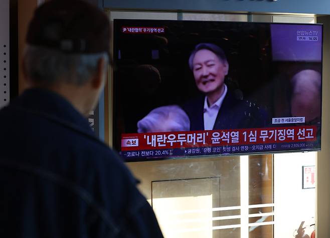 19일 서울 용산구 서울역에서 시민들이 '내란 우두머리 혐의' 윤석열 전 대통령의 1심 선고 공판 중계를 시청하고 있다. 윤 전 대통령은 1심에서 무기징역을 선고 받았다. /뉴시스