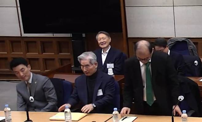 윤석열 전 대통령이 19일 서울중앙지법에서 열린 12·3 불법계엄 관련 내란 우두머리 혐의 1심 선고공판에 출석해 변호인과 대화하며 웃고 있다. 서울중앙지법 제공