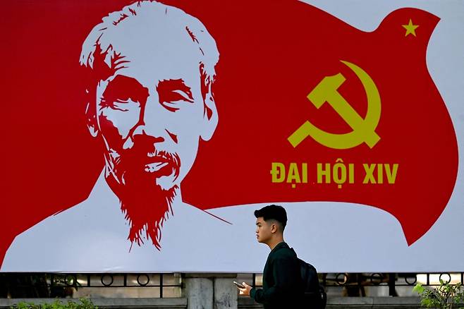 지난 1월 8일(현지시간) 베트남 하노이에서 한 남성이 초대 국가주석 호찌민의 초상이 그려진 ‘제14차 베트남 공산당 전당대회’ 선전판 앞을 지나가고 있다. AFP연합뉴스