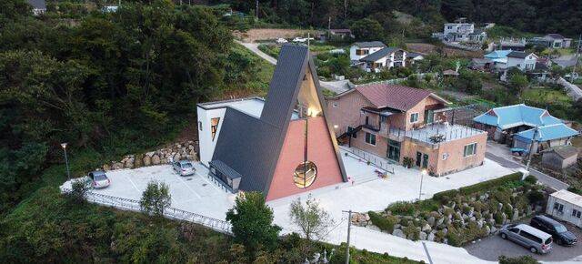 알파벳 ‘A’ 형태로 건축된 강화 길상교회 전경. 꼭대기에는 십자가를 세우고 그 아래에 종을 설치했다. 뒤편에 사각형 매스(덩어리)를 배치해 변화를 주면서 사각형 2층 공간을 소모임실로 사용하게 했다. 오른쪽 건물이 교육관 겸 사택이다. 길상교회 제공