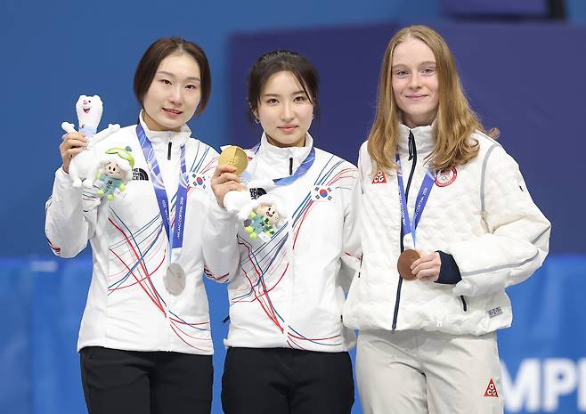 21일 이탈리아 밀라노 아이스스케이팅 아레나에서 열린 2026 밀라노ㆍ코르티나 동계올림픽 쇼트트랙 여자 1500m 시상식에서 금메달을 획득한 김길리와 은메달을 획득한 최민정이 동메달을 획득한 미국의 커린 스토더드와 함께 기념촬영을 하고 있다. [연합]