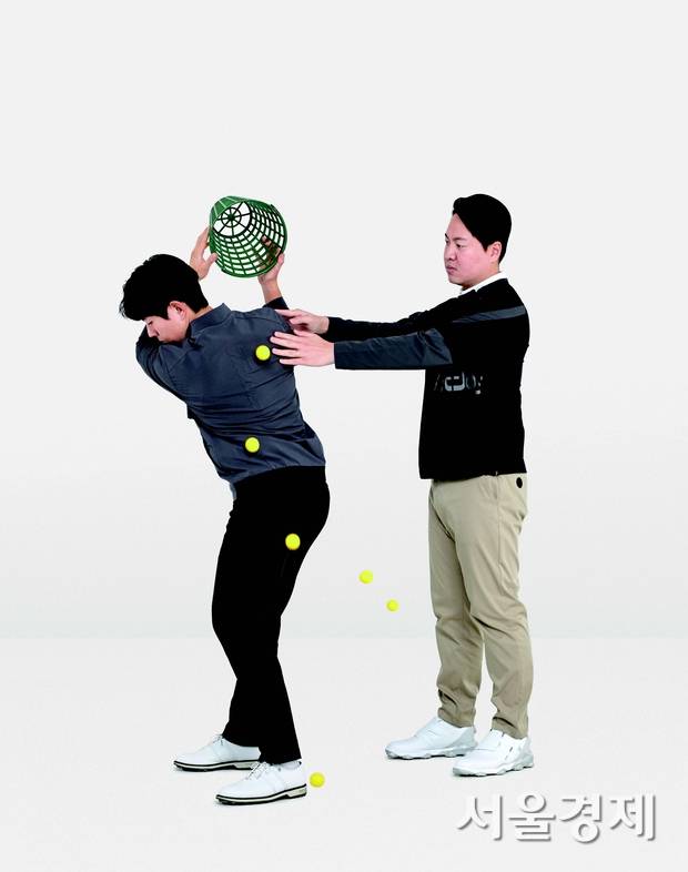 백스윙 톱에서 바구니 속 물건이 등 뒤로 떨어진다면 올바른 동작을 했다는 의미다.