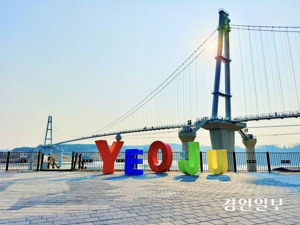 여주 남한강 출렁다리 인근 포토스팟에 설치된 대형 ‘YEOJU’ 조형물과 출렁다리 전경. 노랑·파랑·주황·초록 등 다채로운 색을 입은 알파벳 조형물은 계절별 테마 컬러 전략과 맞물려 여주 관광의 상징적 이미지로 자리매김하고 있다. 2026.2.20 여주/양동민기자 coa007@kyeongin.com