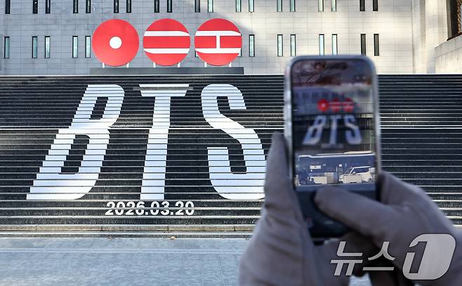 서울 종로구 세종문화회관 계단에 설치된 방탄소년단(BTS)의 정규 5집 컴백을 알리는 홍보물을 배경으로 관광객들이 기념촬영을 하고 있는 모습. 2026.1.22 ⓒ 뉴스1 최지환 기자