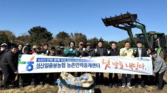 성산일출봉농협 농촌인력중개센터 현장지원 첫 시행을 기념해 관계자와 농업인들이 감자 수확 현장에서 기념 촬영을 하고 있다. (제주농협 제공)