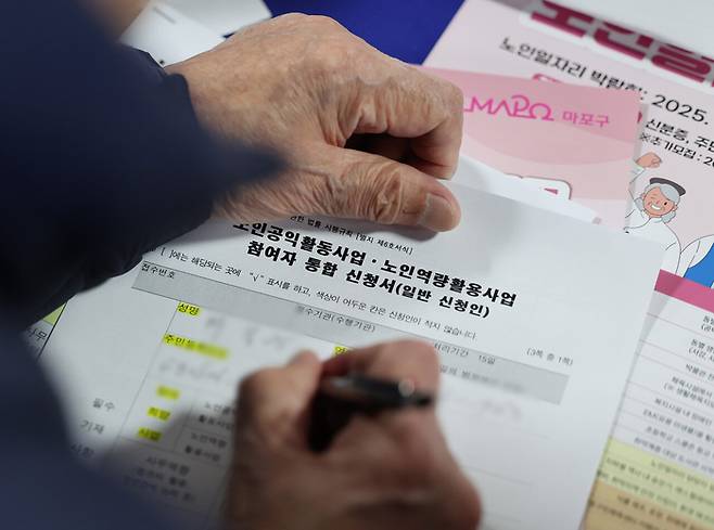 노인일자리 박람회 신청사 작성하는 구직자의 손. [뉴시스]