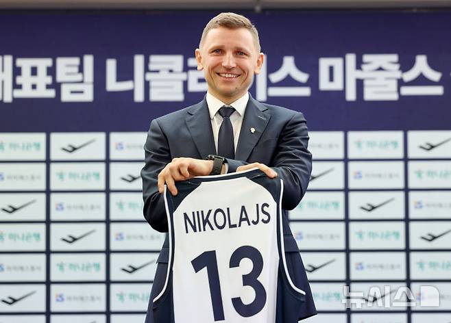 [서울=뉴시스] 김진아 기자 = 남자농구 국가대표팀 니콜라이스 마줄스(Nikolajs Mazurs) 감독이 16일 서울 중구 프레스센터에서 열린 취임 기자회견에서 유니폼을 들고 기념촬영을 하고 있다. 2025.01.16. bluesoda@newsis.com