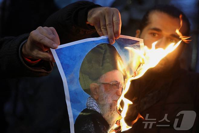 영국 런던에 모인 이란 반정부 시위대가 아야톨라 알리 하메네이 이란 최고지도자의 사진을 불태우고 있다. 2026.01.12 ⓒ 로이터=뉴스1